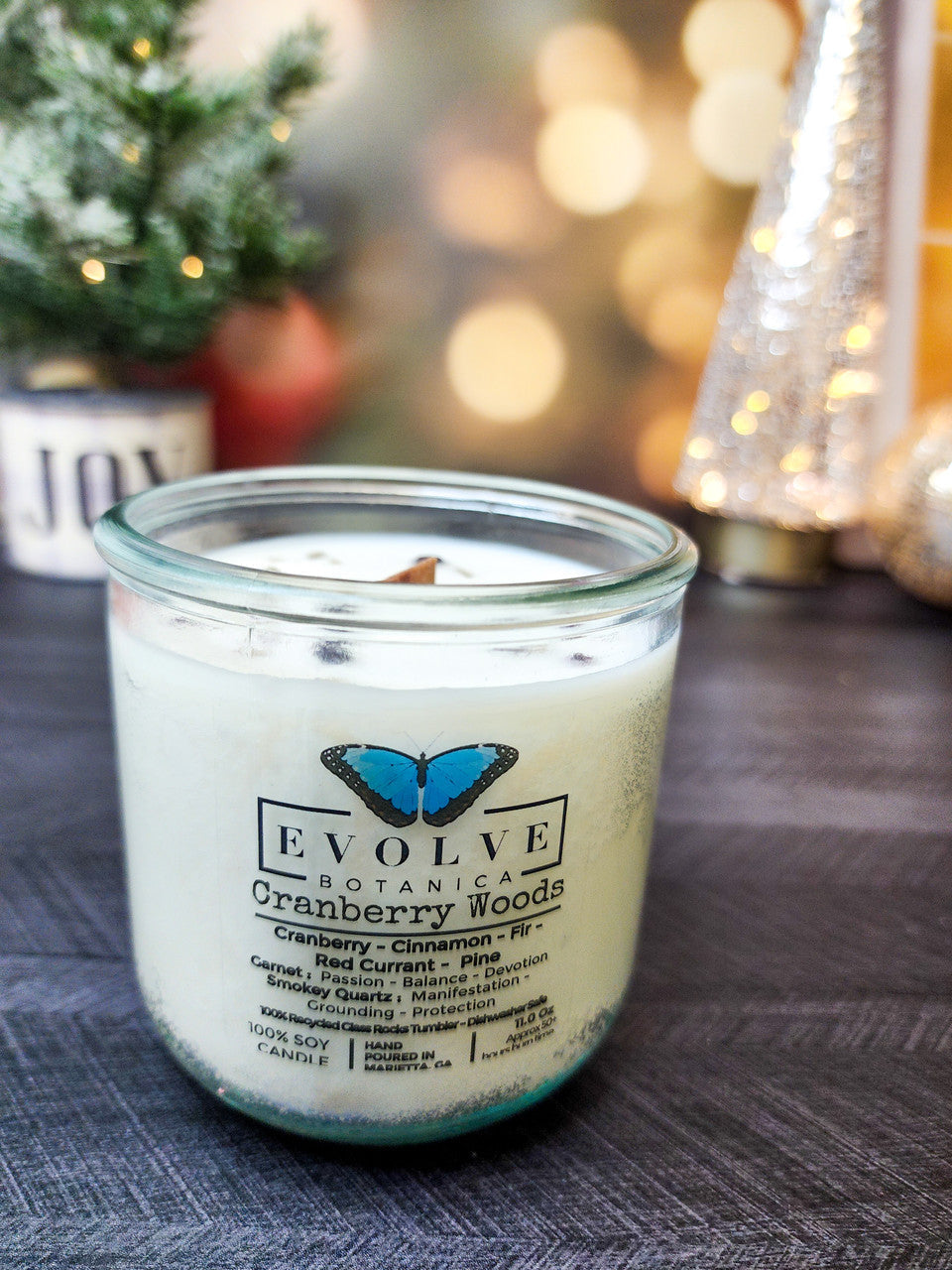 Evolve Botanica Rocks Candle Cranberry Woods soy candle with wood wick, garnet, and smoky quartz gemstones.