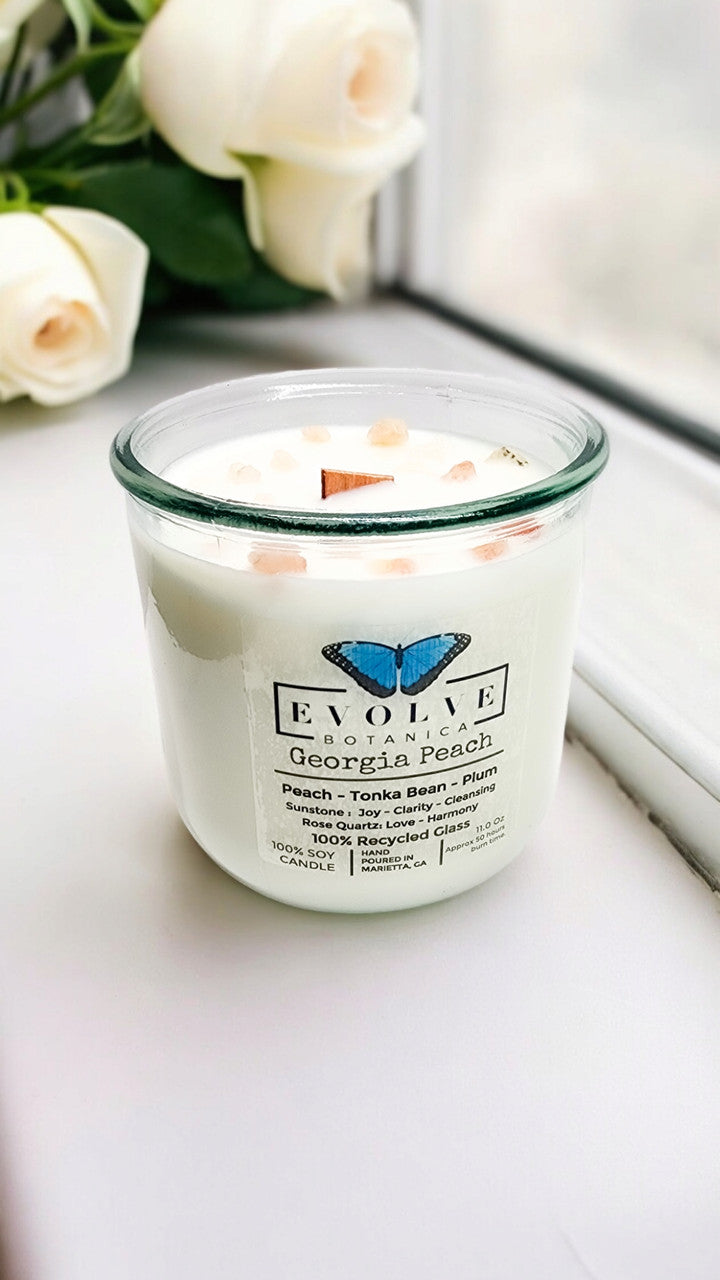 Evolve Botanica Georgia Peach Rocks Candle with wood wick and gemstone, soy wax, in a decorative container.
