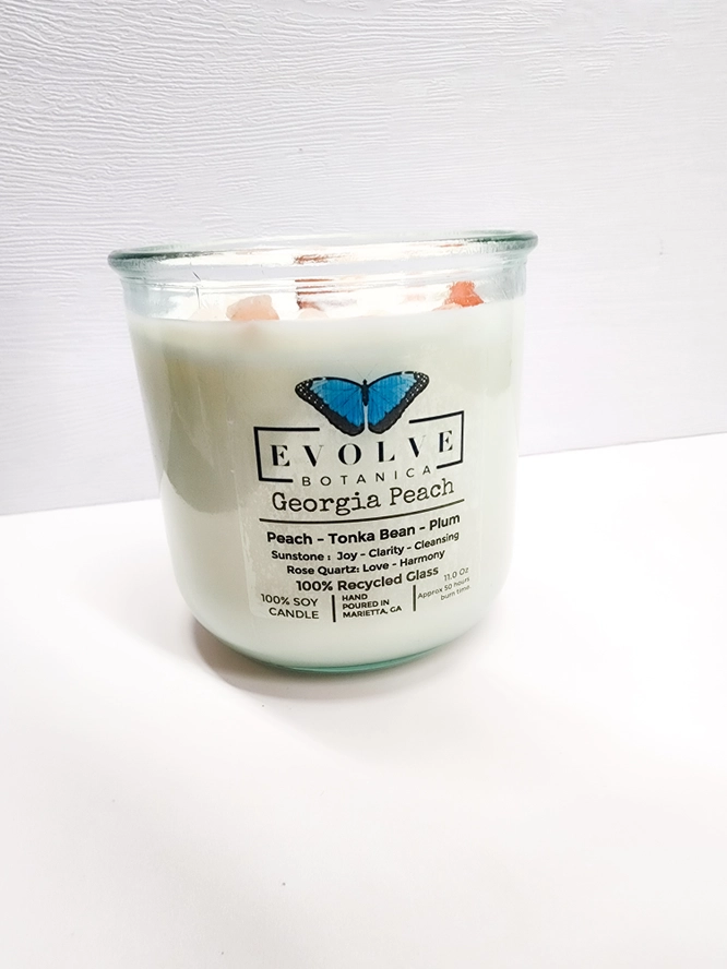 Evolve Botanica Georgia Peach Rocks Candle with wood wick, gemstone accents, and soy wax in a decorative jar.