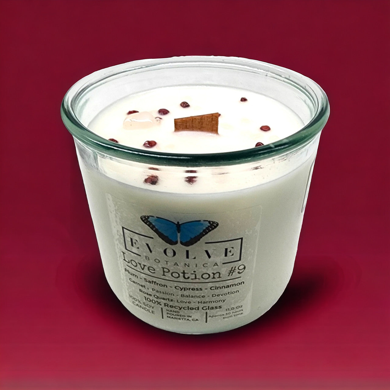 Evolve Botanica Rocks Candle Love Potion #9 with wood wick, garnet and rose quartz gemstones, soy wax, decorative and aromatic.