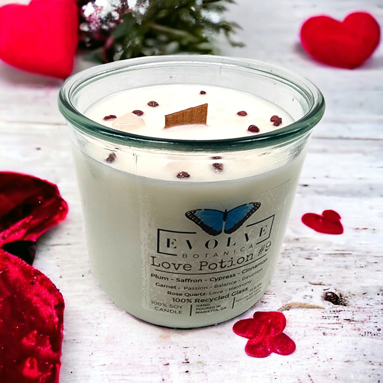 Evolve Botanica Love Potion #9 candle with garnet and rose quartz gemstones, featuring a wood wick and soy wax.