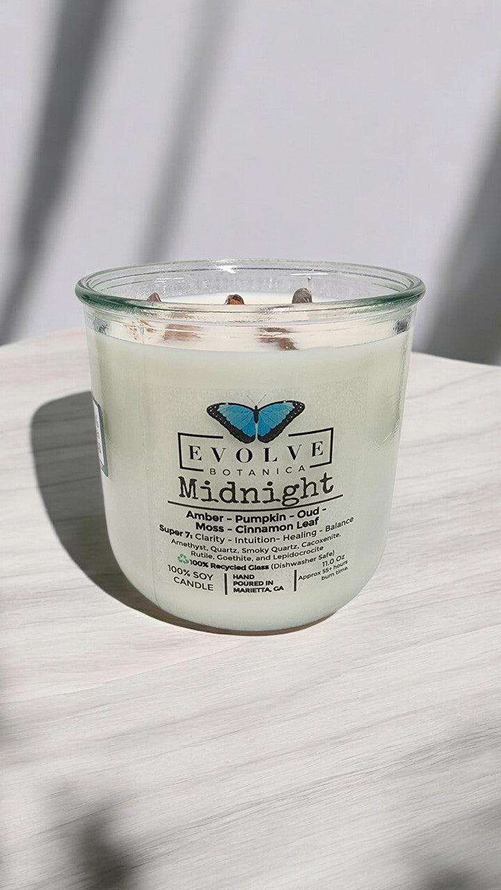 Evolve Botanica Midnight Rocks Candle with wood wick and Super Seven gemstone, soy wax, elegant dark design, calming ambiance.