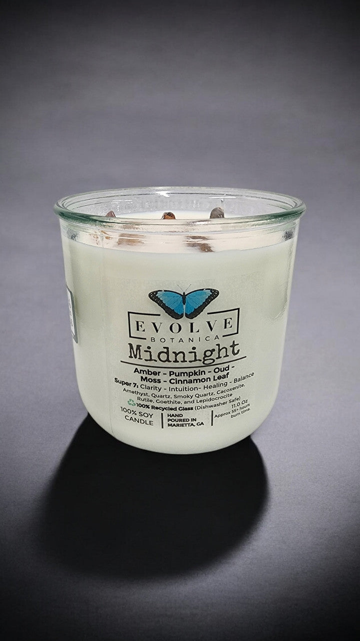 Evolve Botanica Midnight Rocks Candle with wood wick and Super Seven gemstone, soy wax, and calming aesthetic.