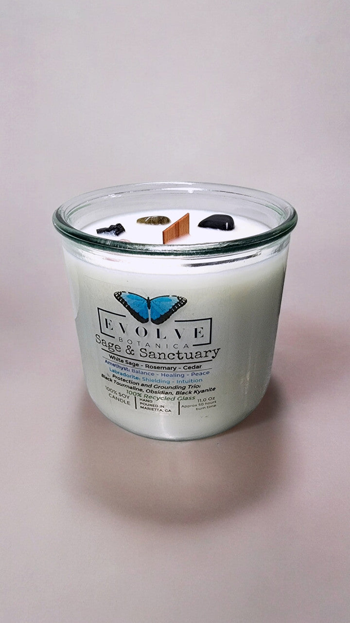 Rocks Candle Sage & Sanctuary by Evolve Botanica with black kyanite, tourmaline, obsidian, amethyst, and labradorite crystals.