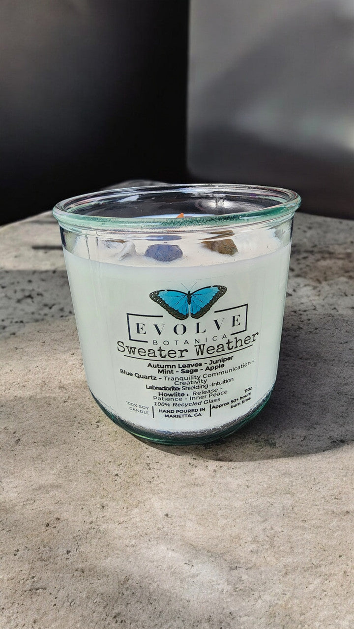 Evolve Botanica Rocks Candle Sweater Weather with wood wick, howlite, labradorite, and sodalite, soy wax for a calming ambiance.