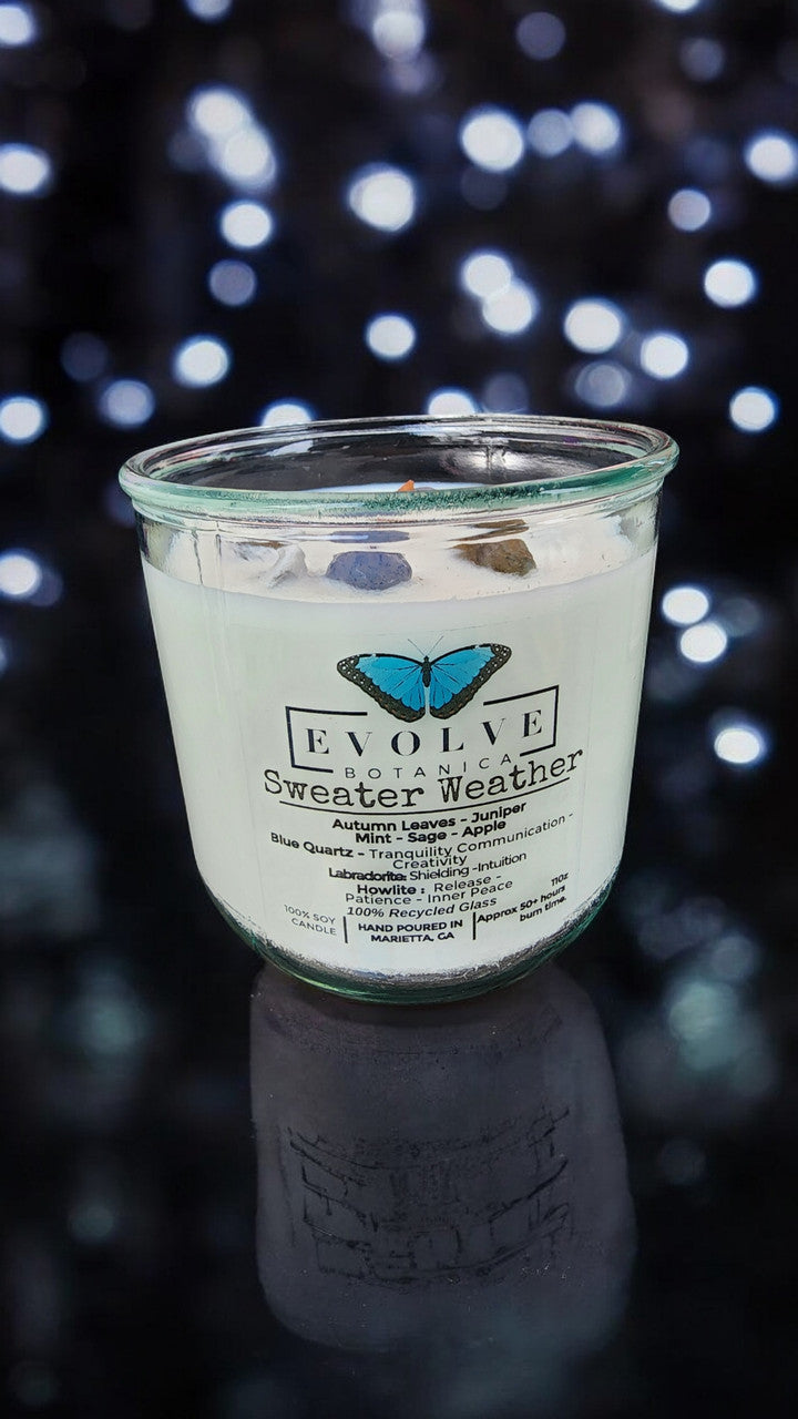 Evolve Botanica Rocks Candle Sweater Weather with wood wick, Howlite, Labradorite, Sodalite, soy wax, in a cozy setting.