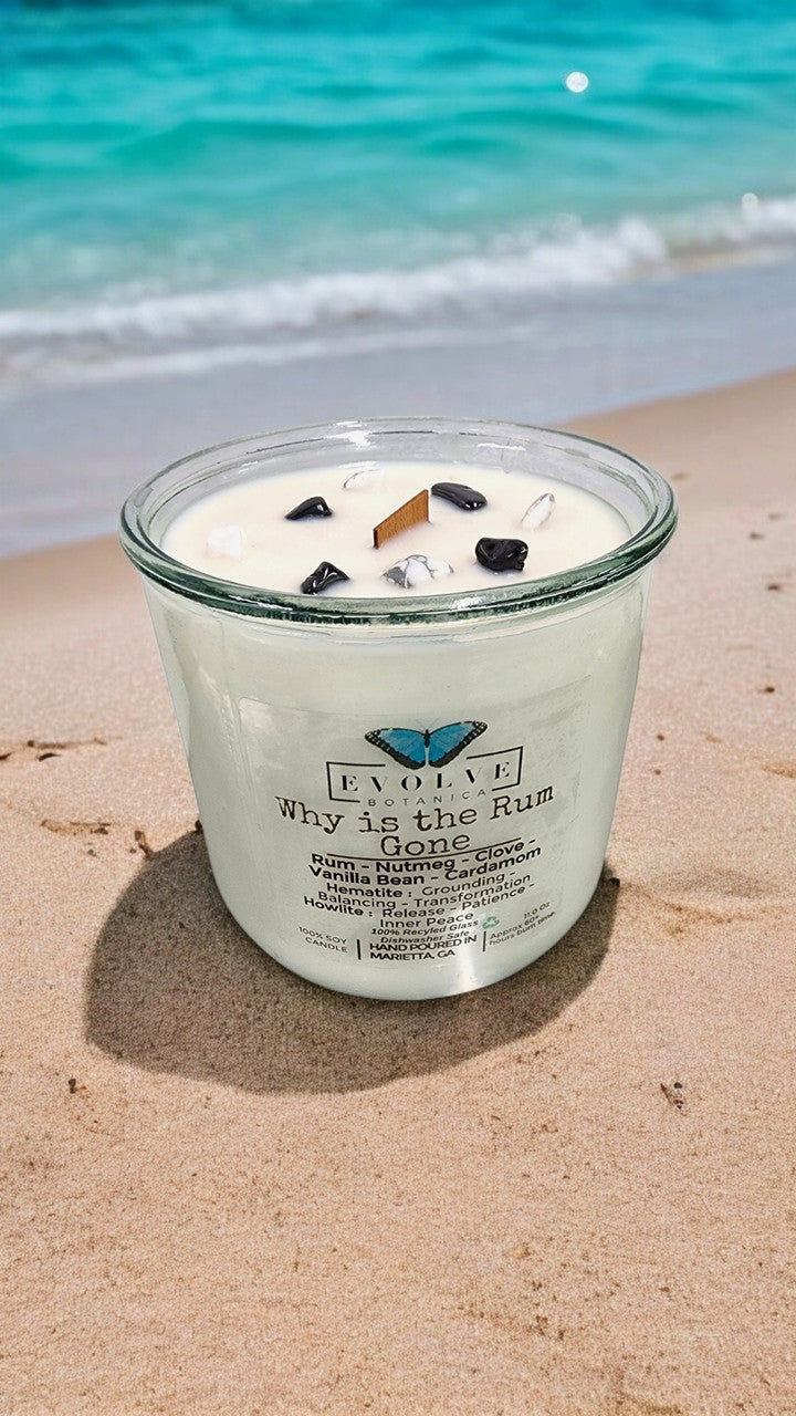 Evolve Botanica Rocks Candle "Why Is The Rum Gone?" with wood wick, hematite, and howlite stones for grounding and inner peace.