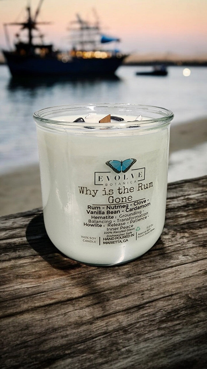Evolve Botanica Rocks Candle "Why Is The Rum Gone?" with wood wick, hematite, and howlite for grounding, balancing, and inner peace.