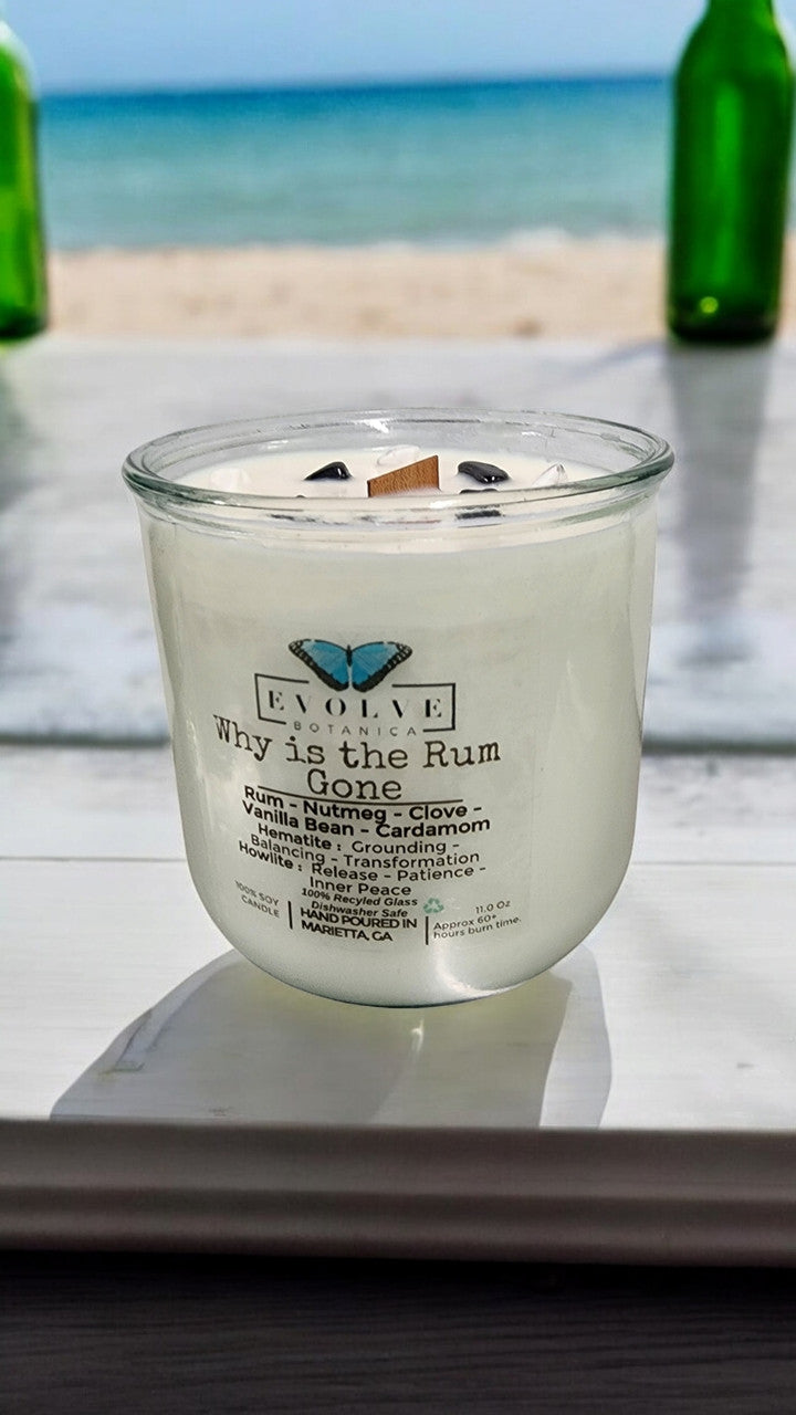 Evolve Botanica Rocks Candle "Why Is The Rum Gone?" with hematite and howlite stones, featuring a wood wick for grounding and relaxation.