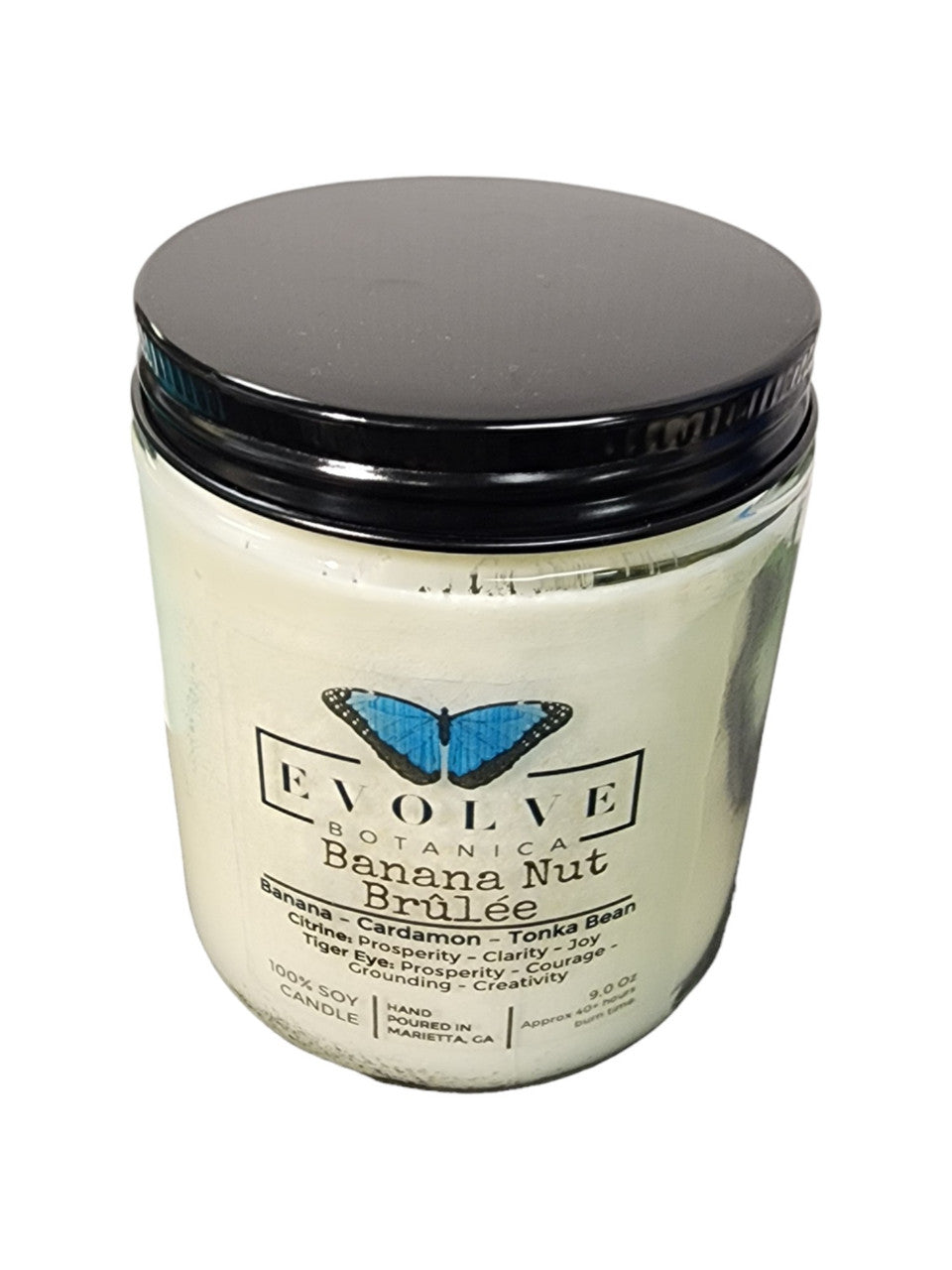 Evolve Botanica 9oz jam jar soy candle with banana nut brulee scent, featuring Citrine and Tiger's Eye crystals and a natural wood wick.