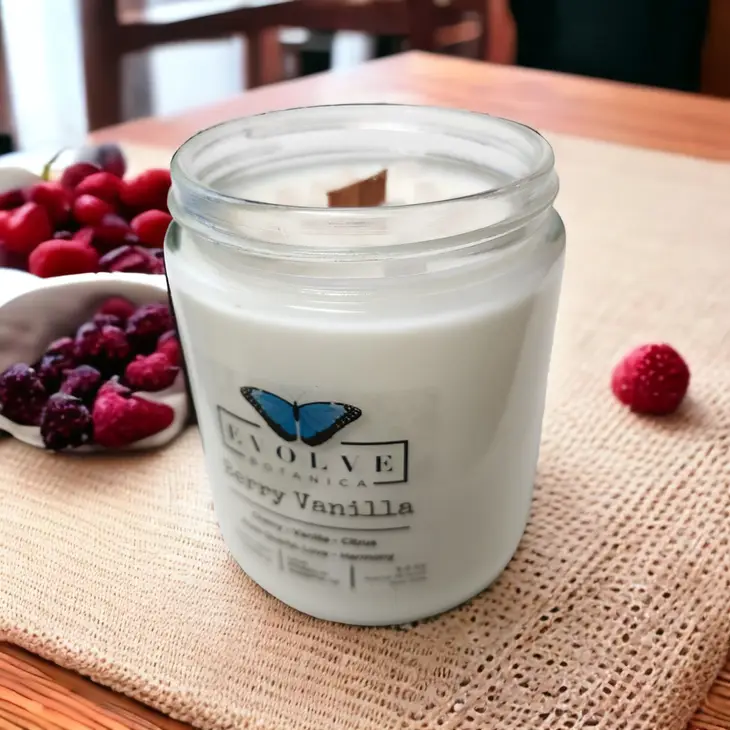 Classic 9oz jam jar soy candle by Evolve Botanica with berry vanilla scent and rose quartz crystal, natural wood wick.