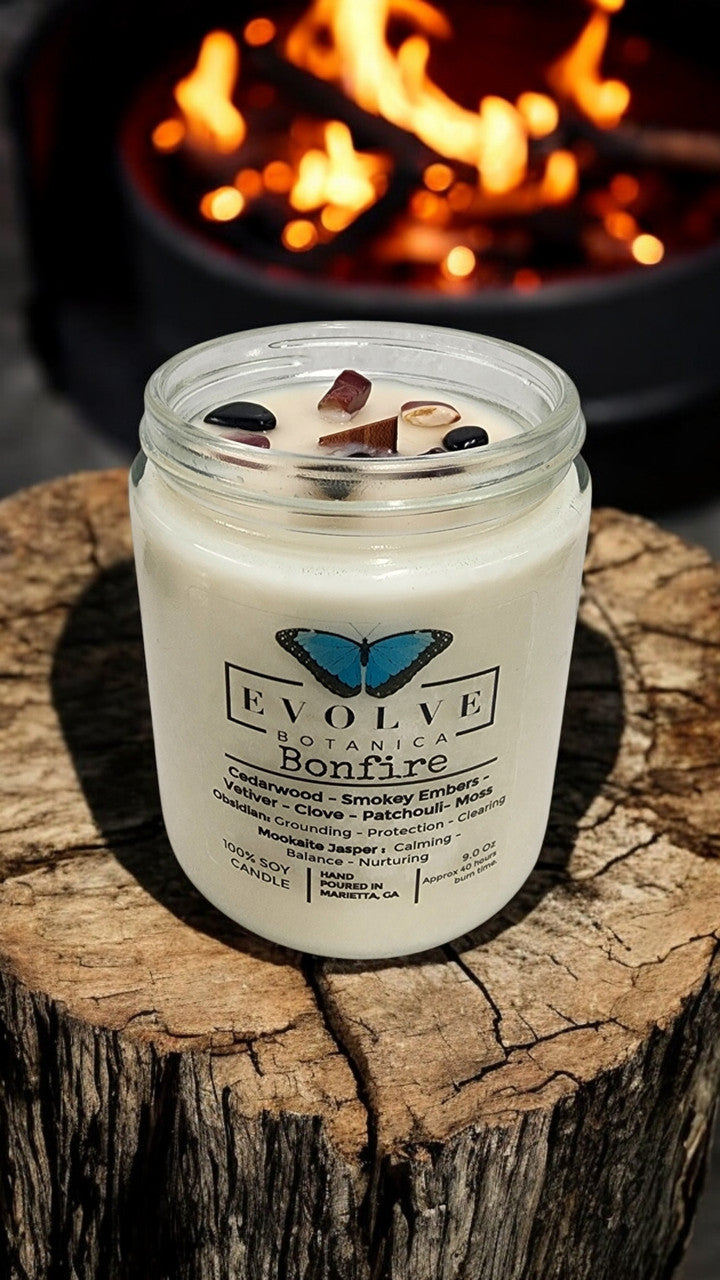 Evolve Botanica 9oz jam jar crystal soy candle with natural wood wick, featuring Obsidian and Mookaite for a bonfire scent.