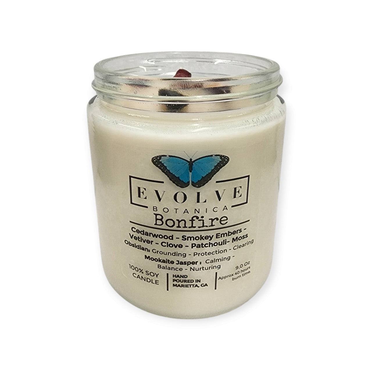 Evolve Botanica 9oz jam jar crystal soy candle with natural wood wick, Bonfire scent, featuring obsidian and mookaite crystals inside.