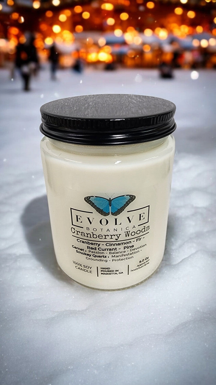 Evolve Botanica 9oz jam jar soy candle with cranberry woods scent, garnet and smoky quartz crystals, natural wood wick.
