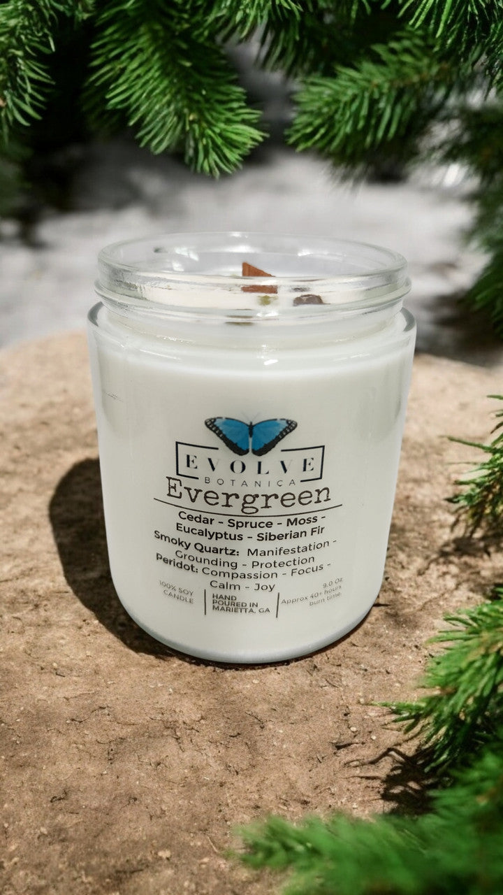 Evolve Botanica 9oz jam jar soy candle with evergreen scent, smoky quartz, and peridot crystals, natural wood wick for a cozy ambiance.