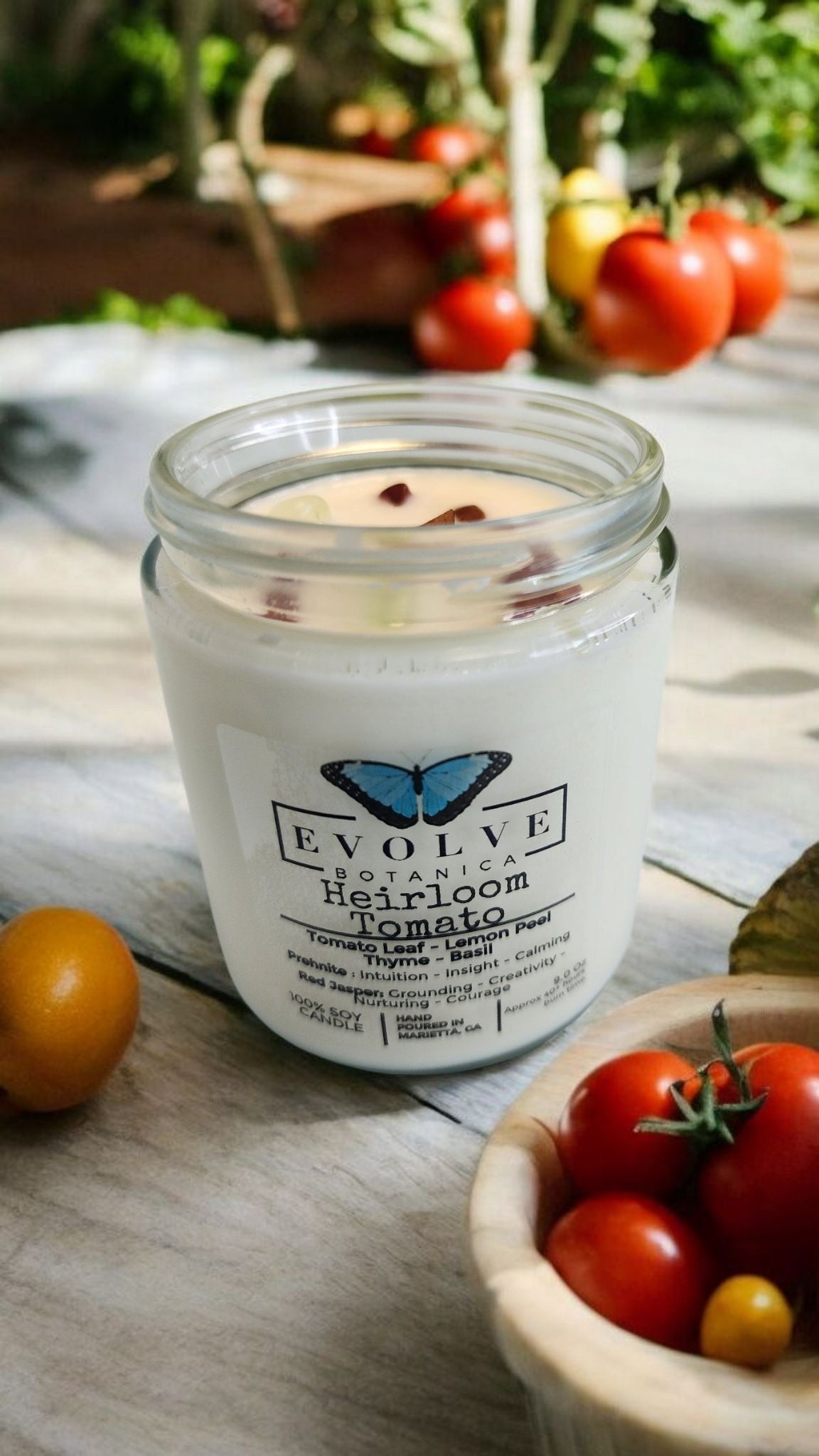 Evolve Botanica 9oz jam jar soy candle with heirloom tomato scent, featuring crystal accents of prehnite and red jasper, natural wood wick