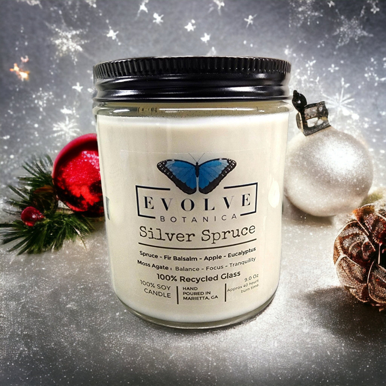 Evolve Botanica 9oz jam jar soy candle with silver spruce scent, crystal moss agate, natural wood wick, and elegant design