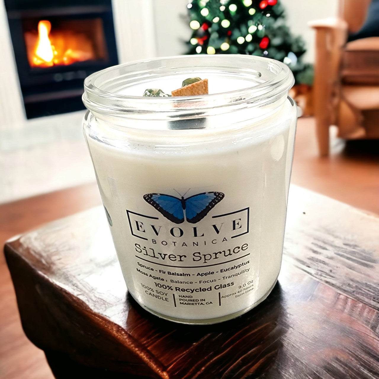 Classic 9oz Jam Jar soy candle by Evolve Botanica in Silver Spruce with Moss Agate, featuring a natural wood wick and crystal accents.
