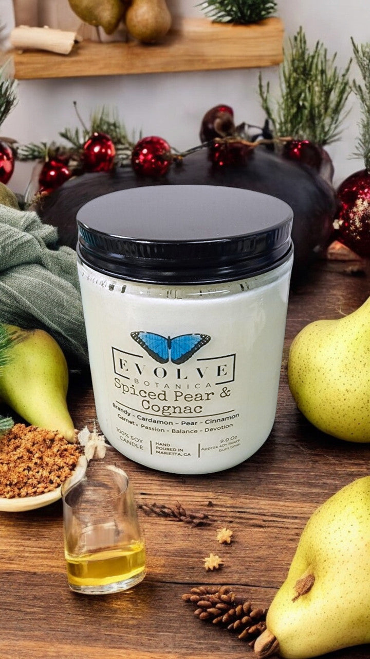 Evolve Botanica 9oz jam jar crystal soy candle with natural wood wick in Spiced Pear & Cognac scent, garnet-colored wax.