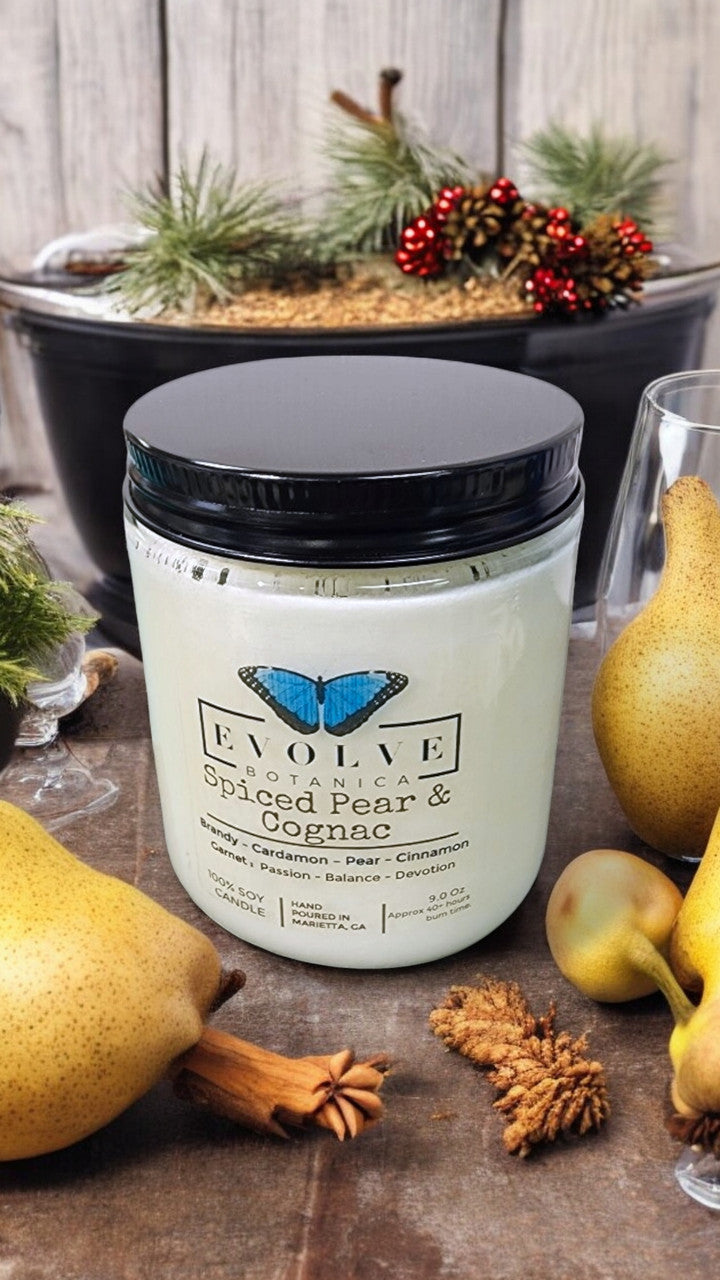 Evolve Botanica 9oz jam jar crystal soy candle with natural wood wick, Spiced Pear & Cognac scent, garnet-colored wax.