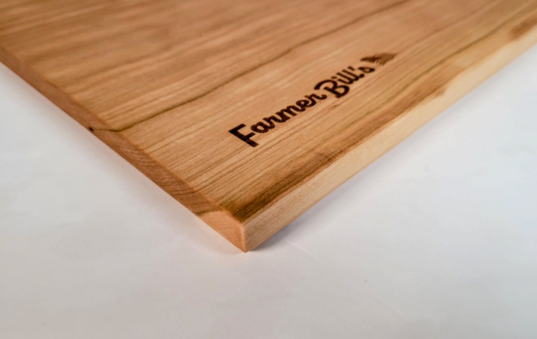 Cherrywood cutting board by Farmer Bill's Provisions, made and sourced in the USA, showing the natural wood grain and sturdy construction.