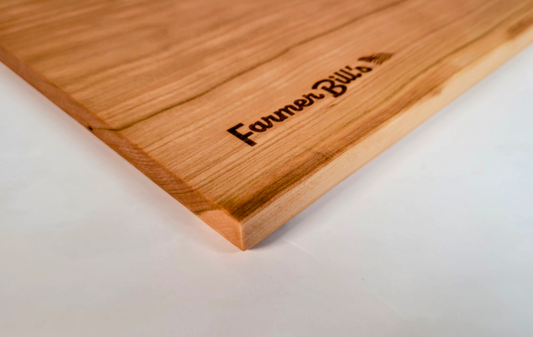 Cherrywood cutting board by Farmer Bill's Provisions, made and sourced in the USA, showing the natural wood grain and sturdy construction.