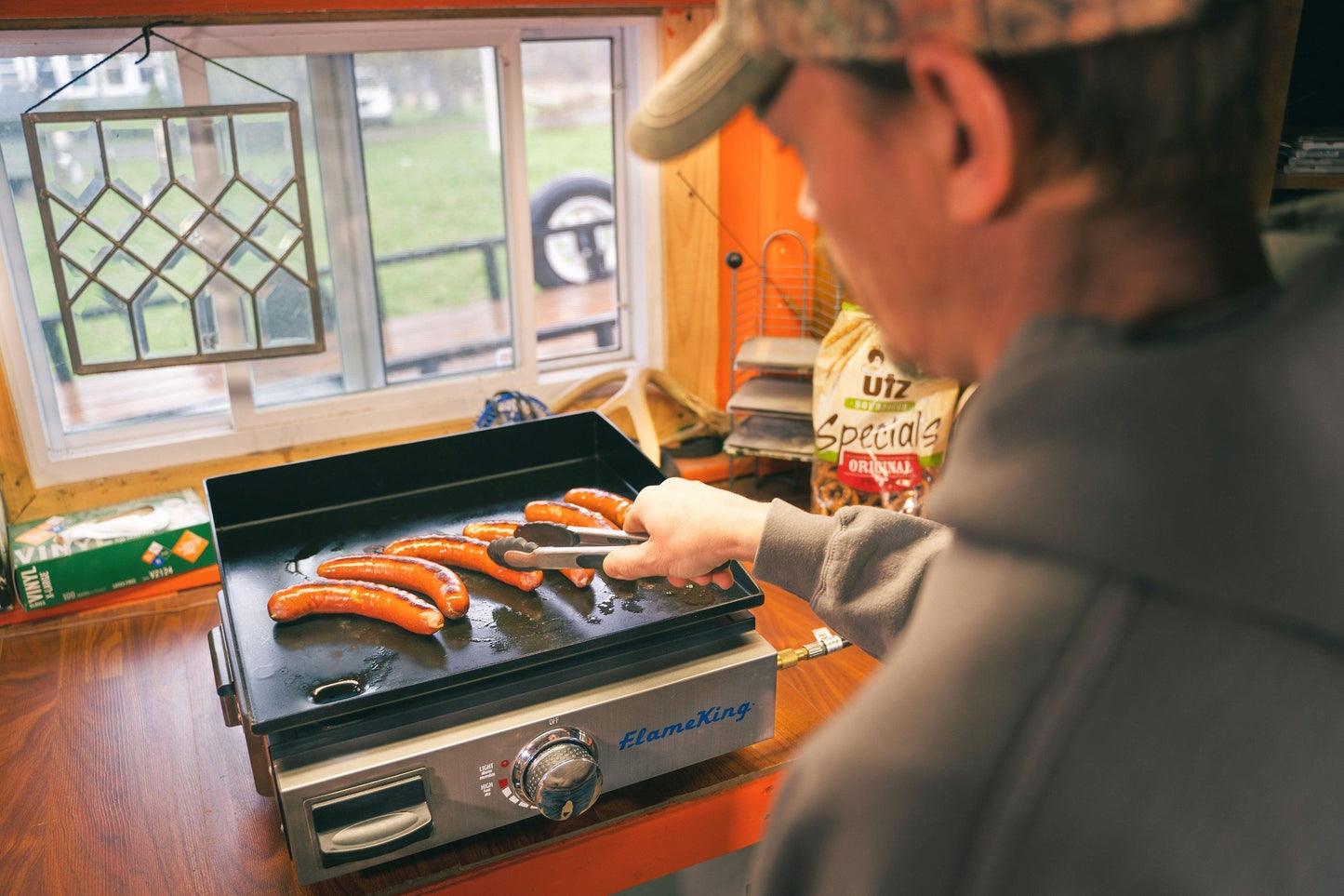 Flame King flat top portable propane cast iron grill griddle for camping, showing the black cast iron surface and compact design.