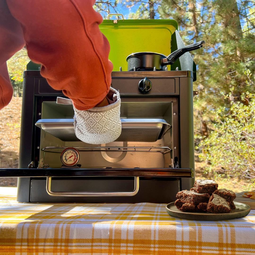 Portable Flame King camping oven and stove combo with compact design, perfect for outdoor cooking and camping adventures.
