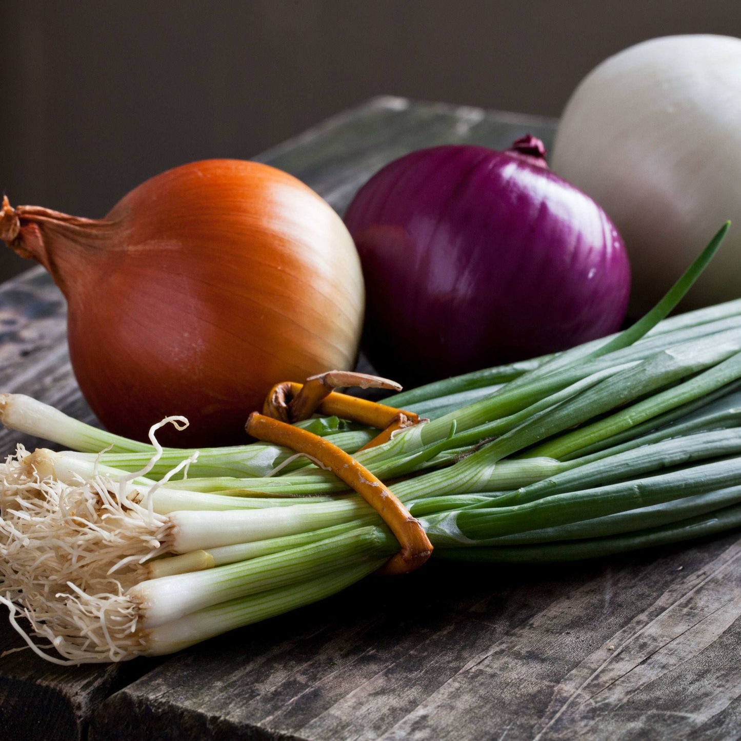 Mixed yellow and red onion sets from Fresh Garden Living, showing 50-60 bulbs of non-GMO onion sets on a garden background.