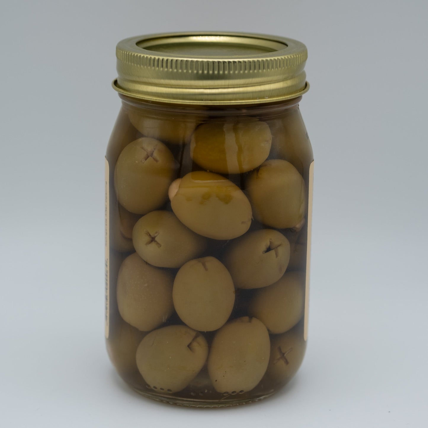 Canned garlic stuffed olives from Amish Country Store in a 16oz jar, showing green olives filled with garlic cloves.