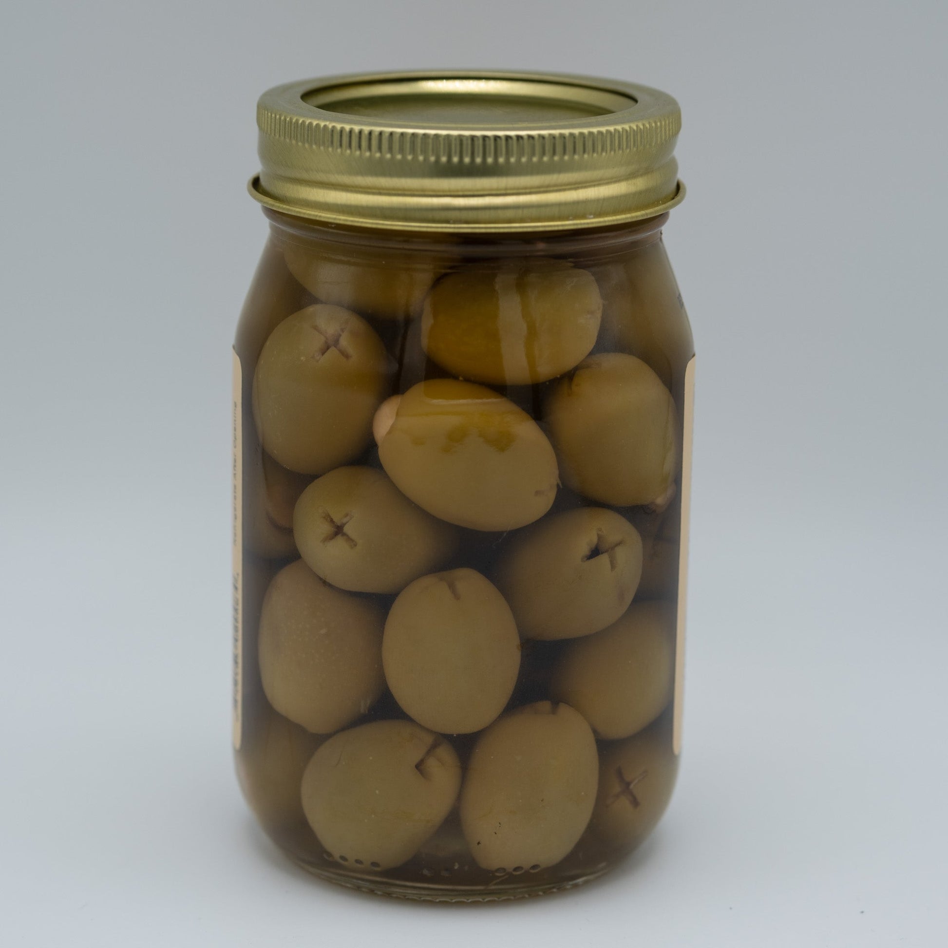 Canned garlic stuffed olives from Amish Country Store in a 16oz jar, showing green olives filled with garlic cloves.