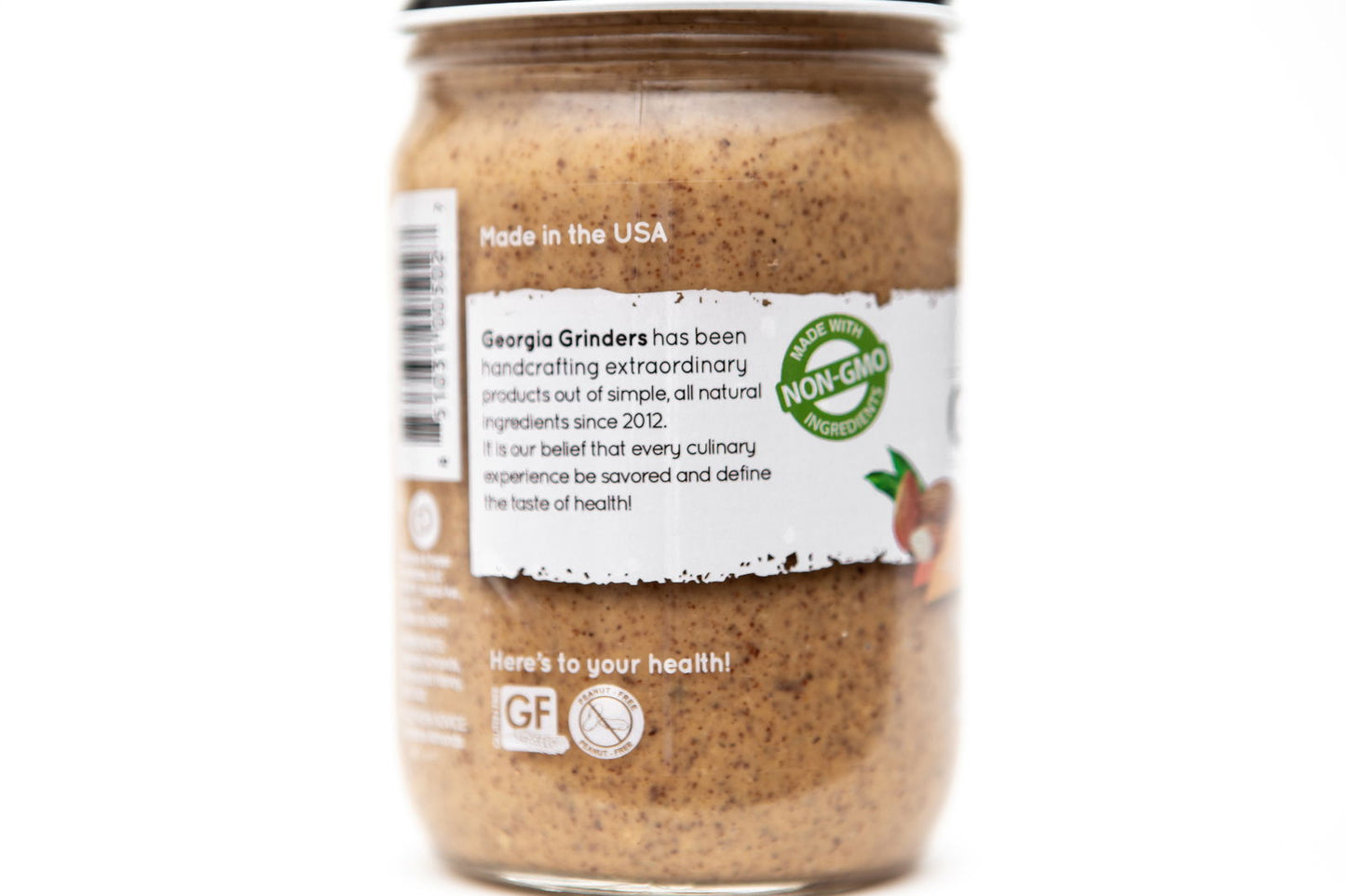 A close-up of the Georgia Grinders Maple Caramel Almond Butter and Honey Roasted Almond Butter Mix Pack (two 12oz jars of each) highlights its handcrafted, all-natural ingredients, non-GMO label, and Made in the USA statement on the jar.