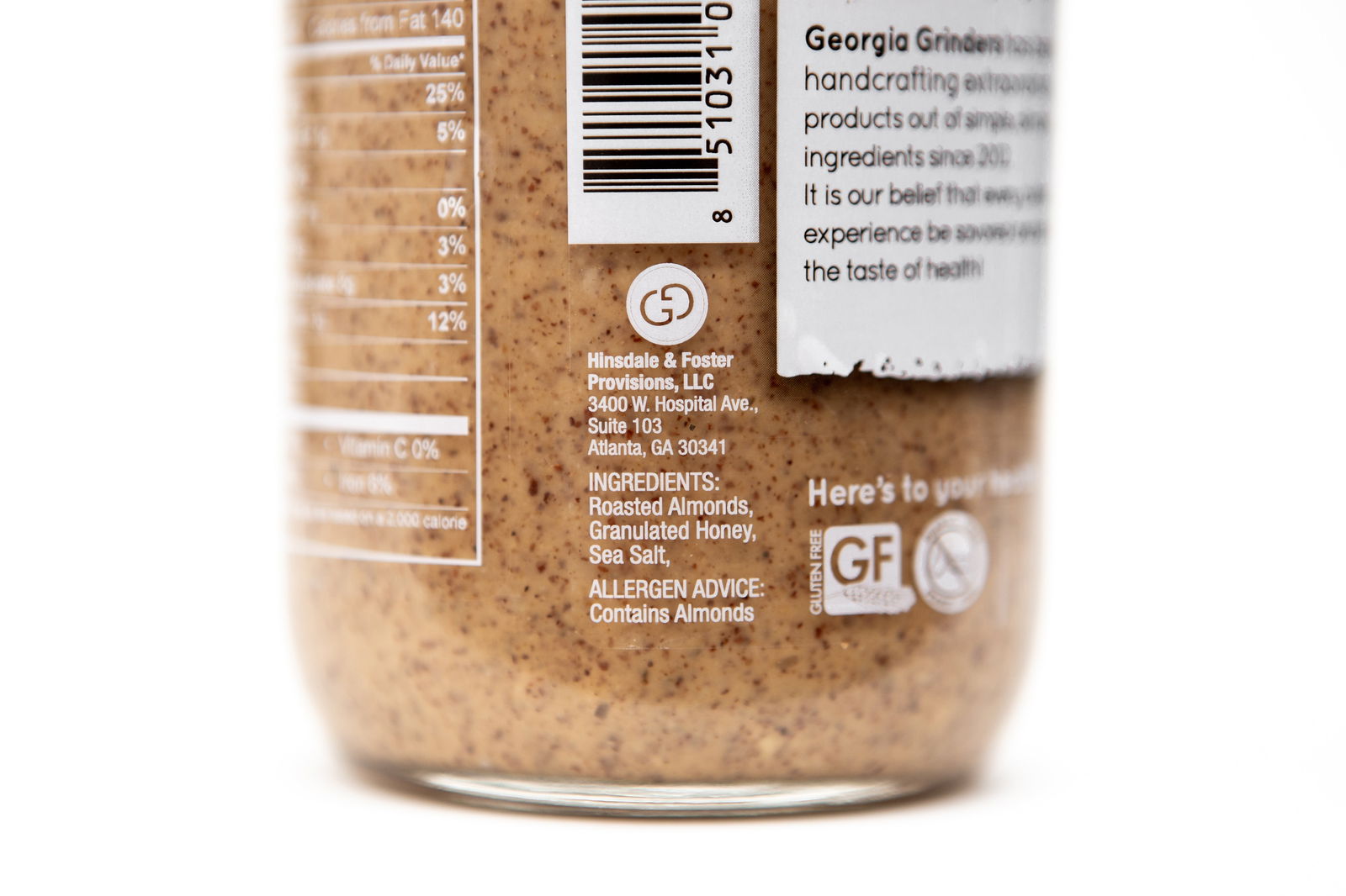 Close-up of a Georgia Grinders Maple Caramel Almond Butter and Honey Roasted Almond Butter Mix Pack jar label showing ingredients like roasted California almonds, granulated honey, sea salt, allergy info (contains almonds), company details, and nutrition facts.