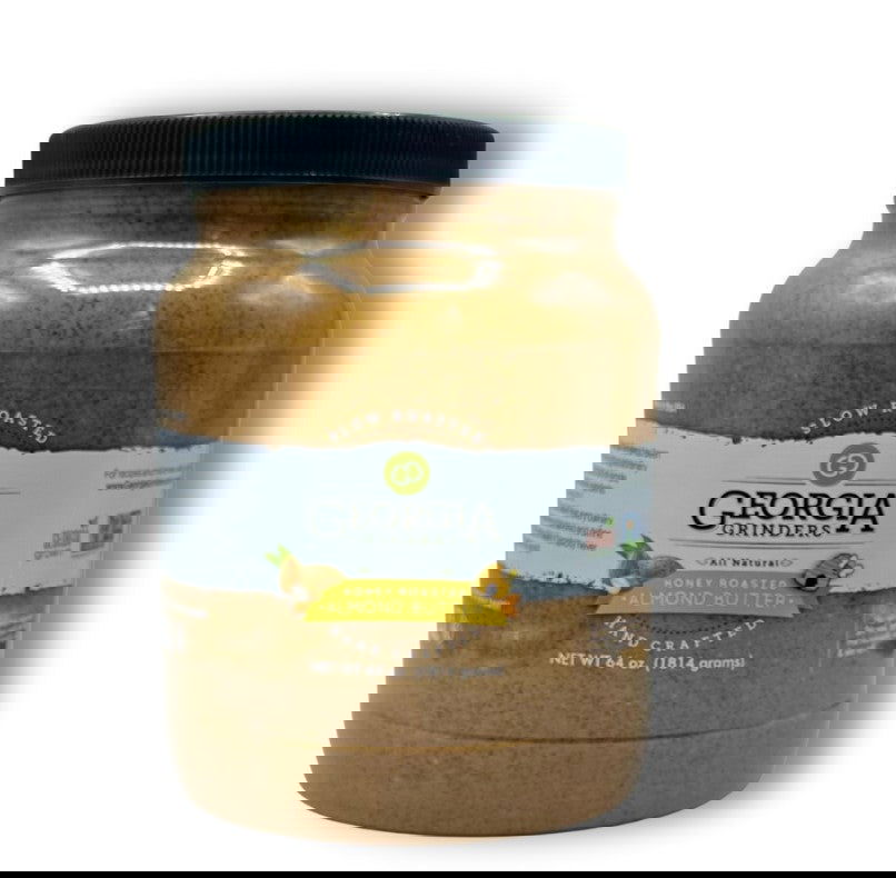 An unclear image shows two overlapping jars with dark lids; one has a white and yellow label, possibly Georgia Grinders 64 oz Bulk Tub of Honey Roasted Almond Butter, while the other features a darker, more detailed label.