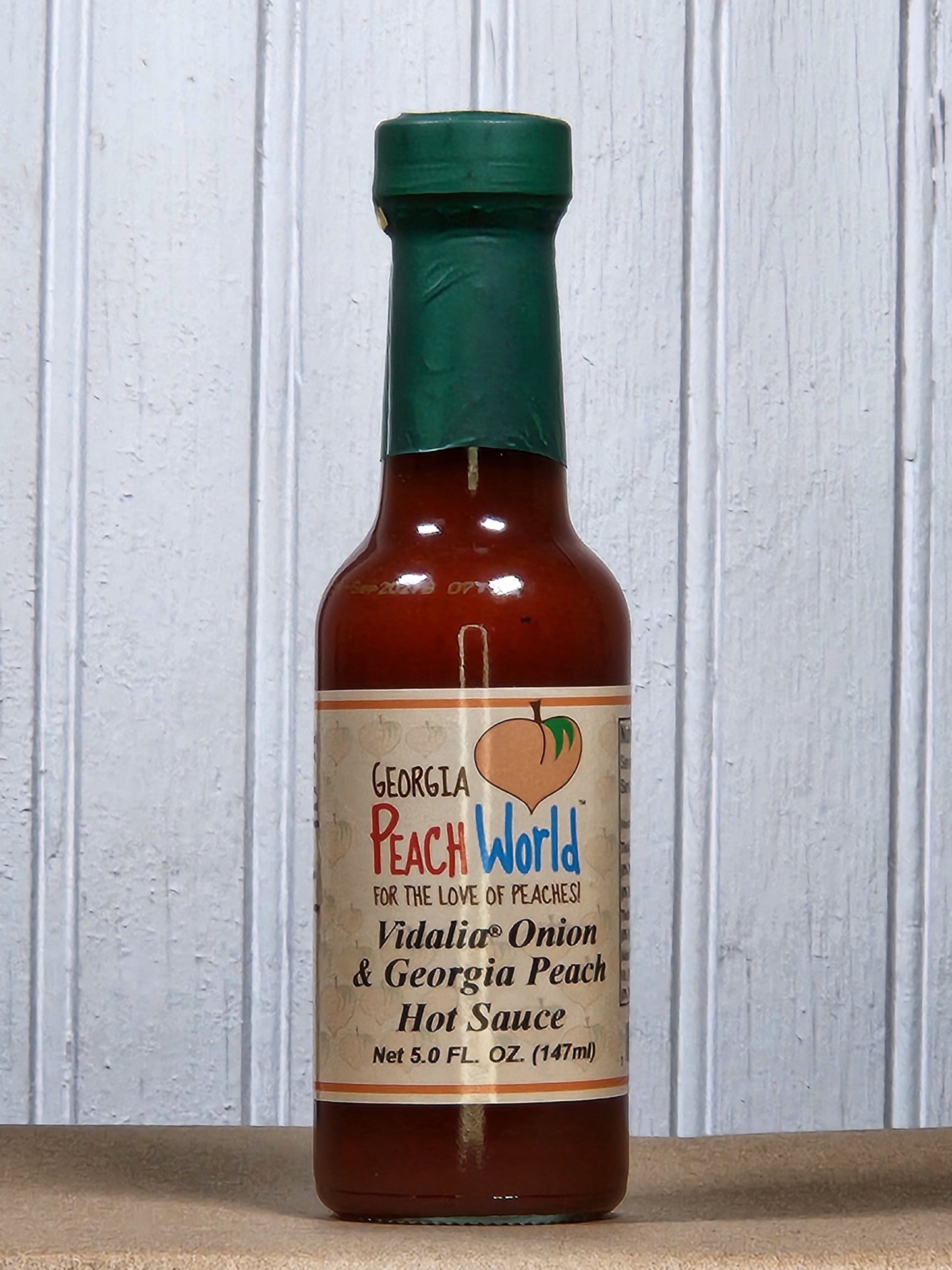 Georgia Peach World Vidalia Onion and Georgia Peach hot sauce bottle, ideal for BBQ and adding flavorful heat to dishes.
