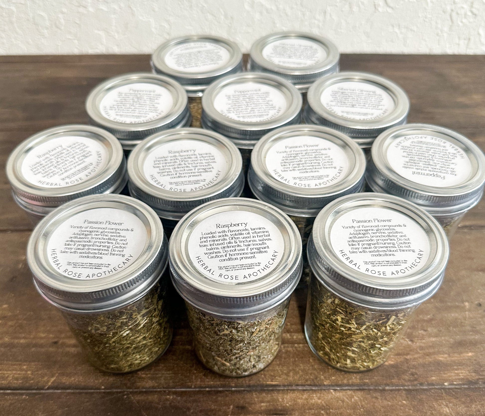 Small glass herb jars filled with dried herbs from HerbalRoseApothecary, perfect for storing herbs and spices.
