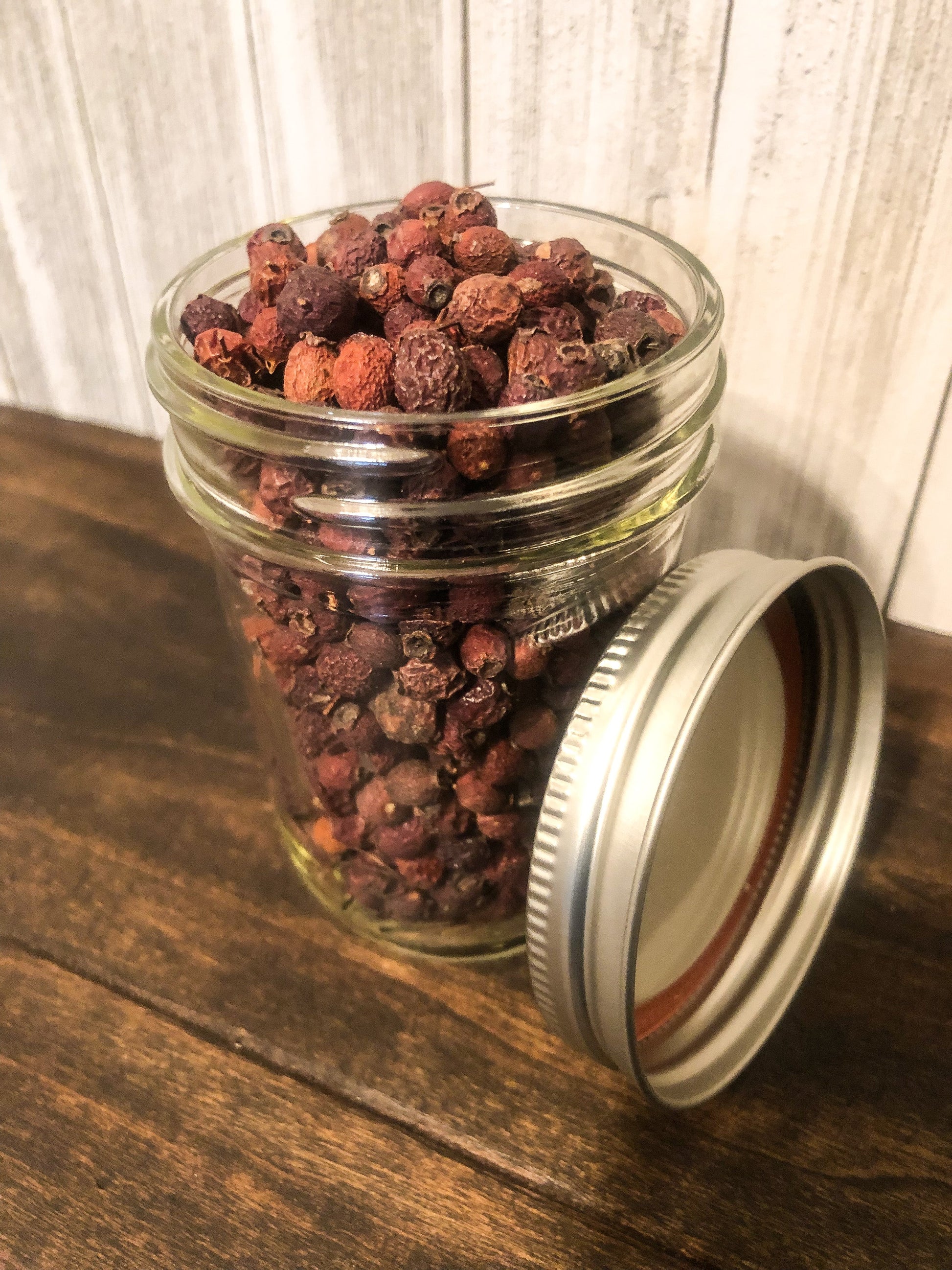 Small jar of dried hawthorn berries in herbalroseapothecary herb jars, showcasing natural herbal ingredients for wellness use.