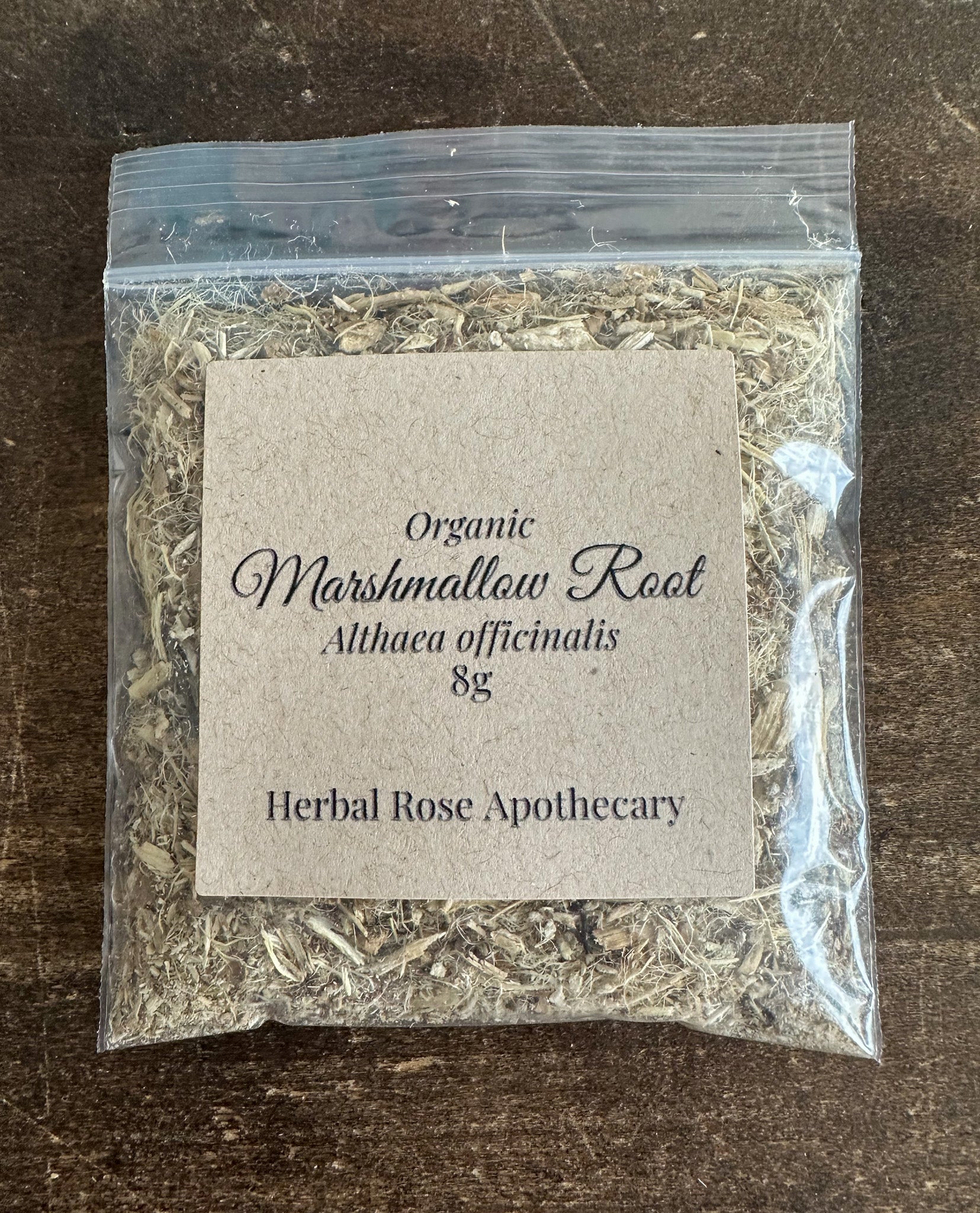 Organic marshmallow root in an 8g package from Herbal Rose Apothecary, showing dried herbal root pieces.