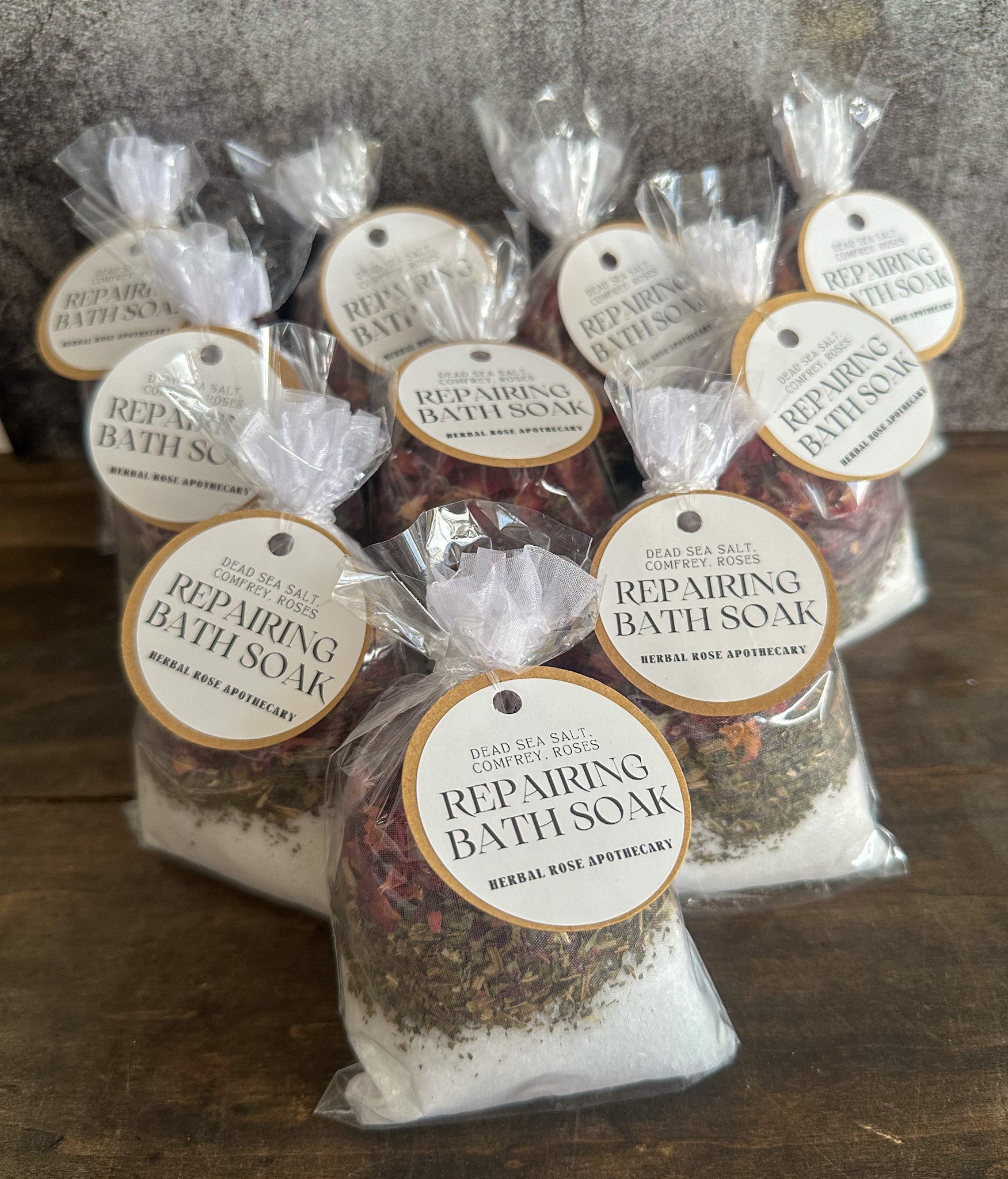 Herbalroseapothecary sore muscle bath soak with Epsom salt, peppermint, and herbs, shown in a clear container with herbal ingredients.