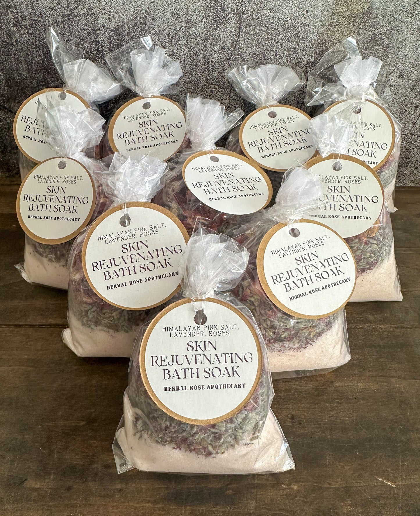 Herbalroseapothecary herbal bath soak with Epsom salt, peppermint, and herbs for sore muscles in a clear glass jar.