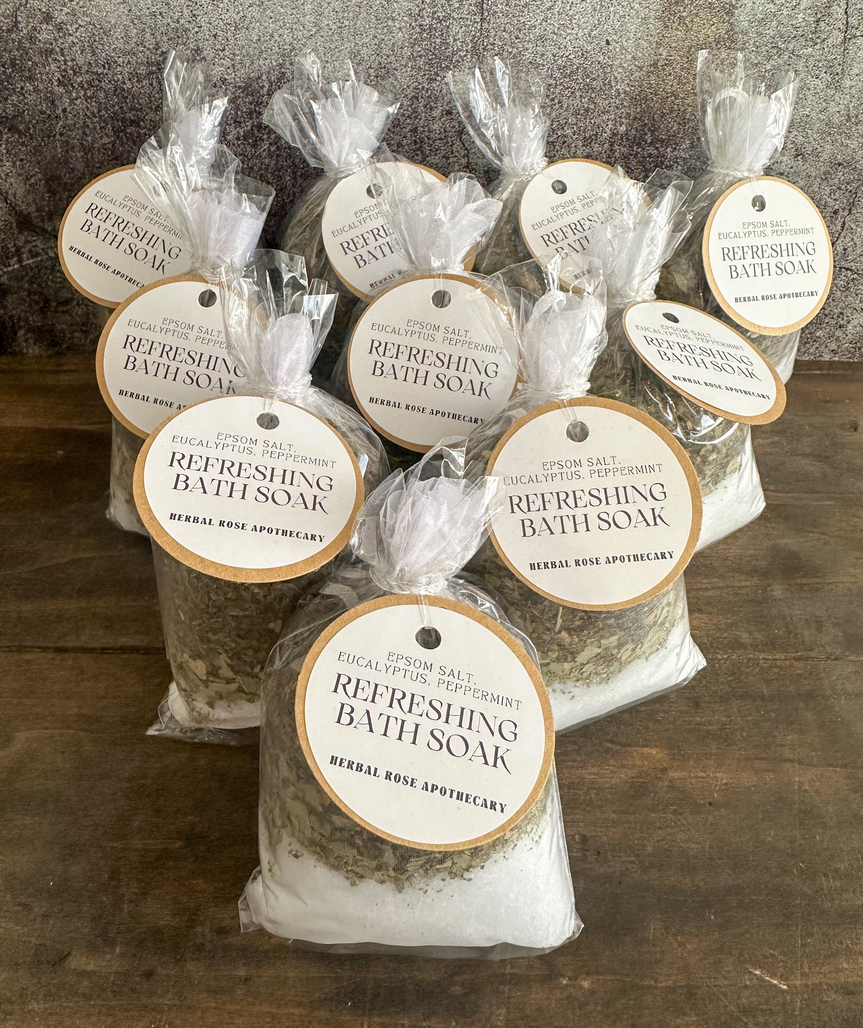 Herbalroseapothecary sore muscle bath soak with Epsom salt, peppermint, and dried herbs in a clear jar for relaxing herbal bath therapy.