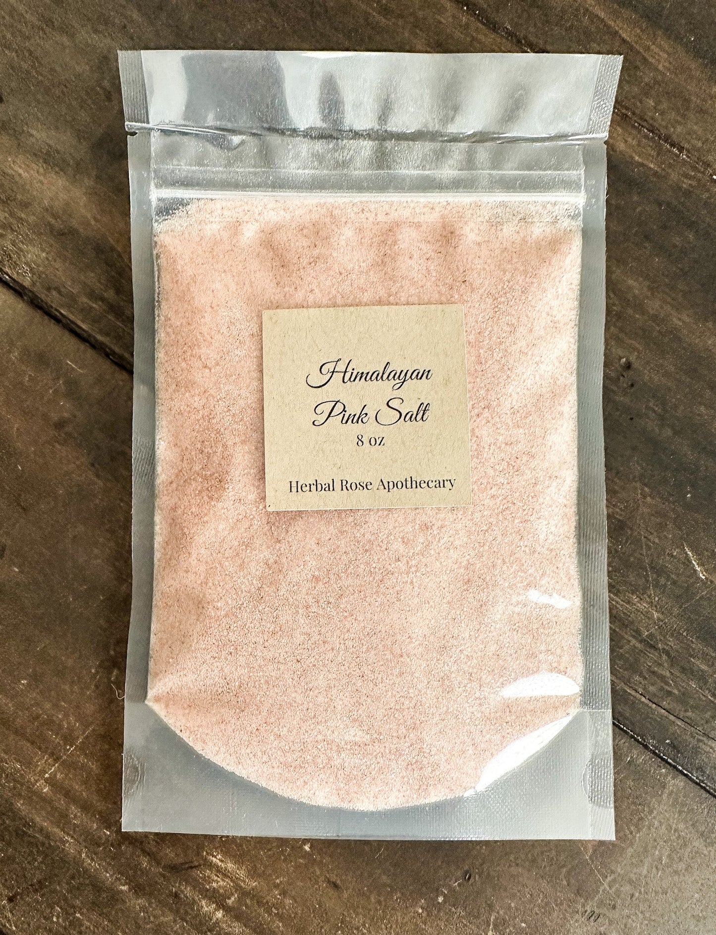 Himalayan pink salt from HerbalRoseApothecary in a clear jar, showcasing coarse pink salt crystals and oats.