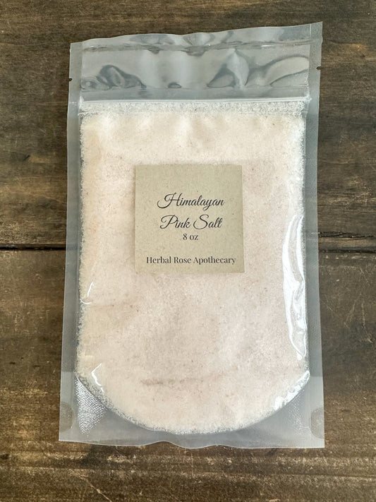 Himalayan Pink Salt from HerbalRoseApothecary, showing coarse pink salt crystals in a clear jar on a white background.