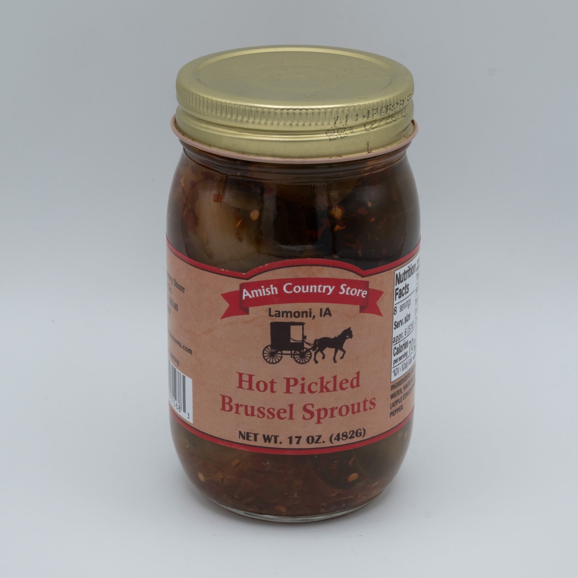 Canned Amish Country Store hot pickled Brussels sprouts in a jar, showing bright green sprouts submerged in spicy brine.