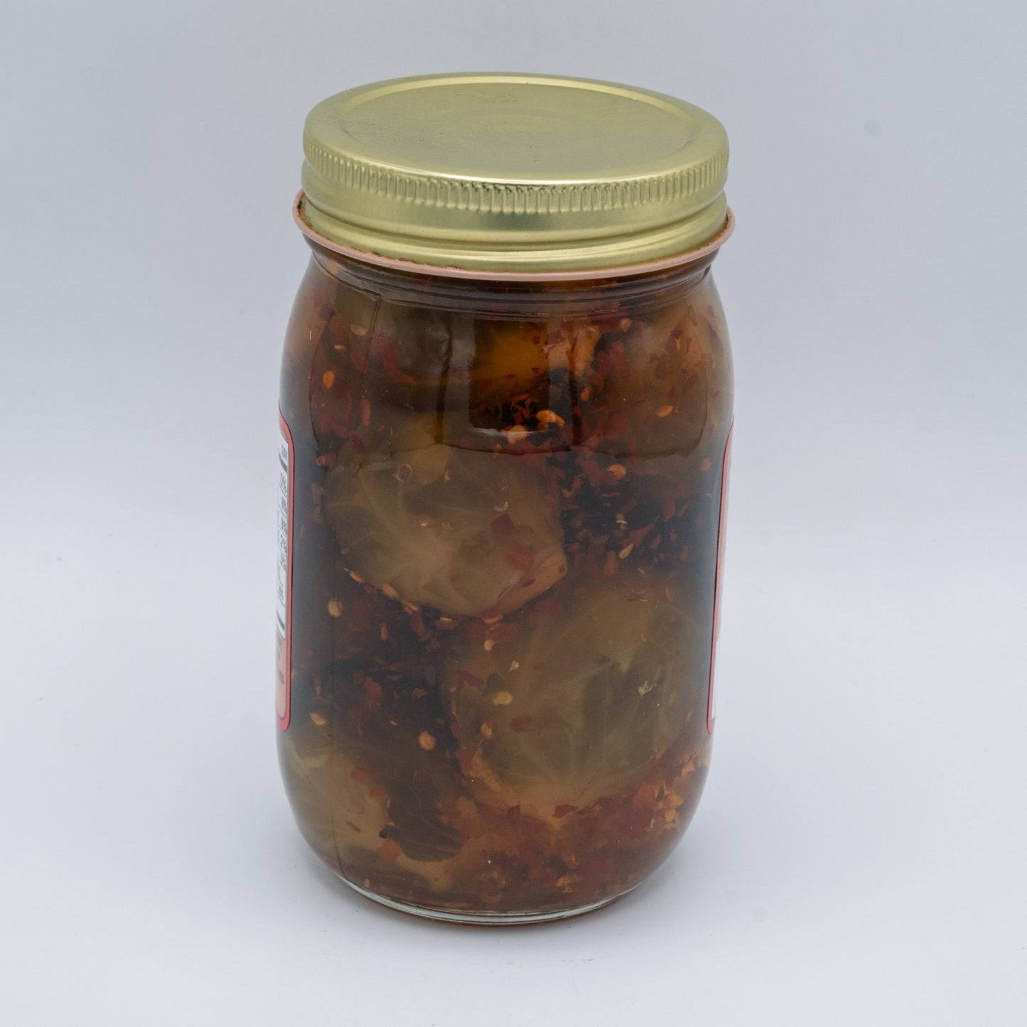 Canned hot pickled Brussels sprouts from Amish Country Store in a glass jar, showing bright green sprouts with red pepper flakes.