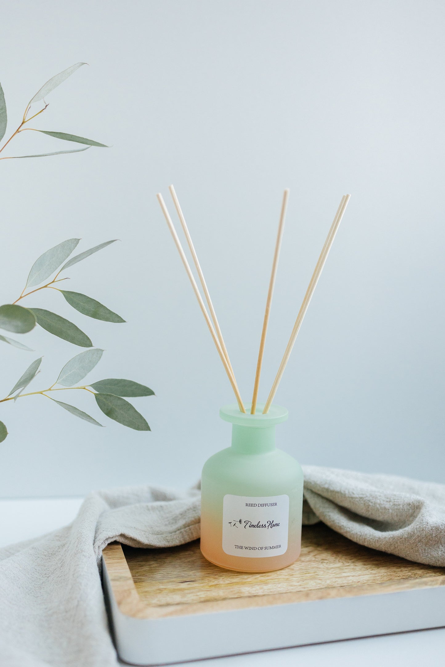 Reed diffuser from Timeless Organics Skin Care, The Wind of Summer scent, with natural reed sticks and a clear glass container.