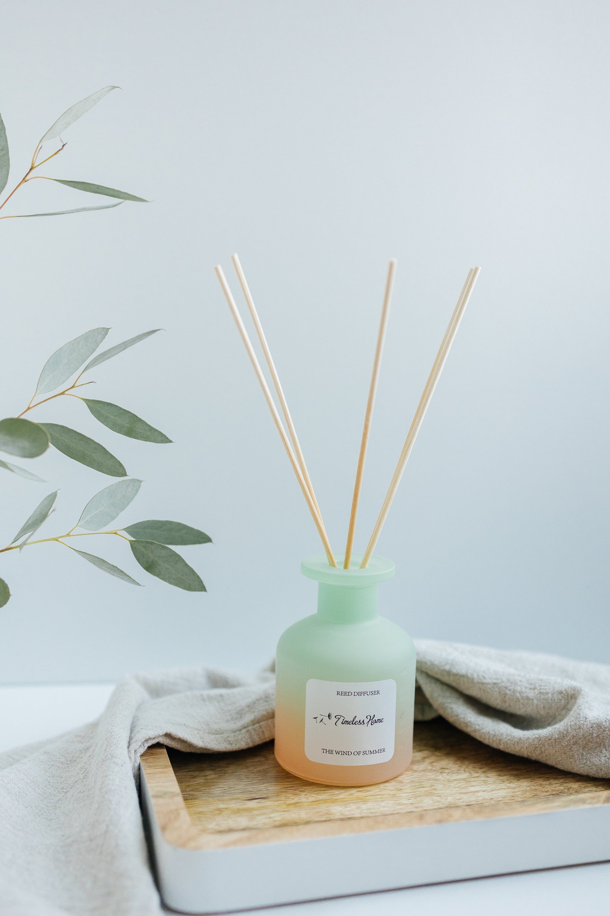 Reed diffuser from Timeless Organics Skin Care, The Wind of Summer scent, with natural reed sticks and a clear glass container.