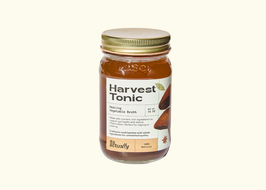 Three 14oz jars of Its Actually Co. Healing Vegetable Broth beverage, showcasing fresh vegetables and clear broth in glass jars.