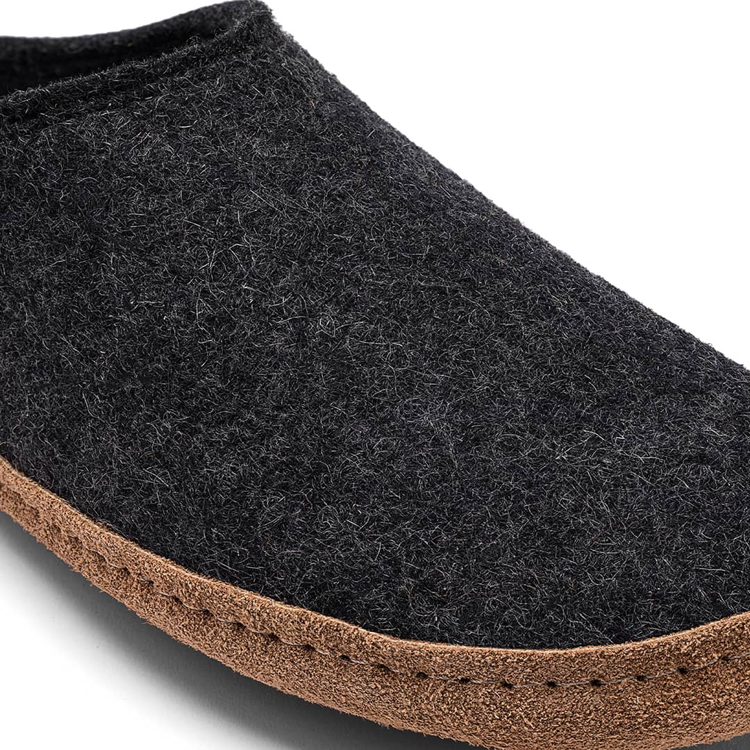 Close-up of Kyrgies Indoor Wool Slides by Kyrgies, featuring a thick brown sole, detailed edge stitching, and the textured wool of these natural biodegradable slippers.