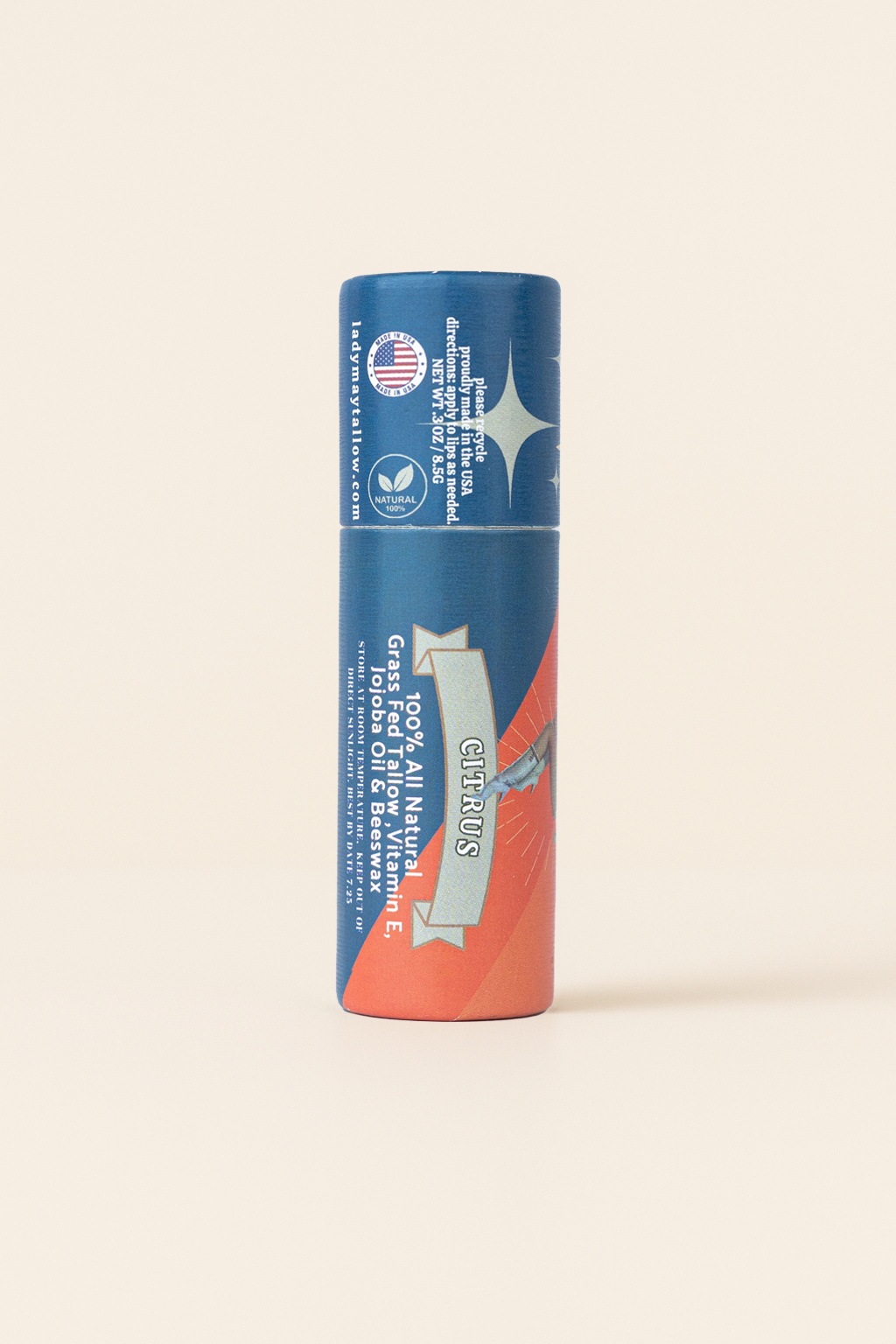 Lady May Tallow Lip Balm comes in a cylindrical tube with blue and orange “CITRUS” packaging. Made by Lady May Tallow, it features vitamin E, jojoba oil, beeswax, is vegan, hydrating, made in the USA, and uses natural ingredients.